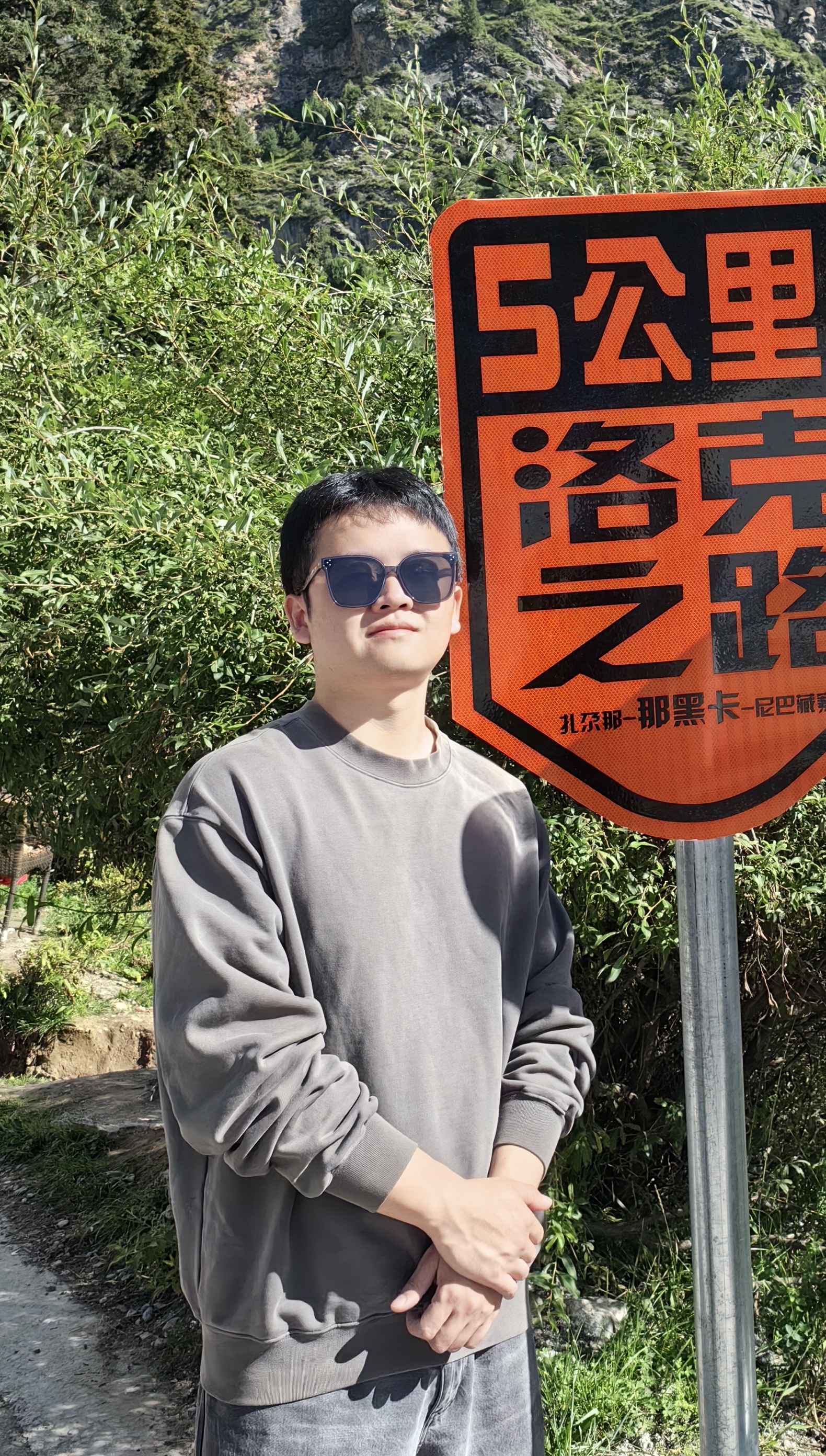 A person standing in front of a signDescription automatically generated