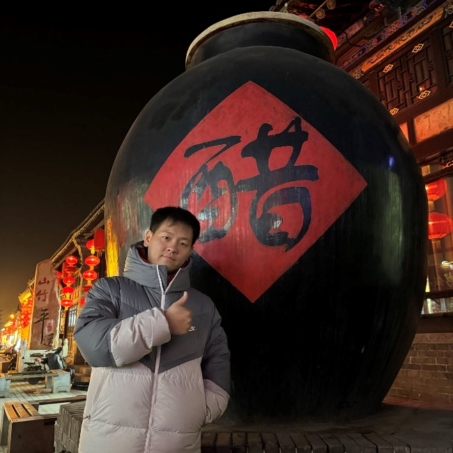 A person standing in front of a large black vaseDescription automatically generated