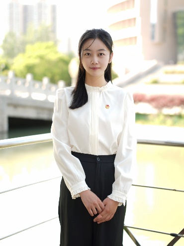 A person in a white blouse and black skirtDescription automatically generated